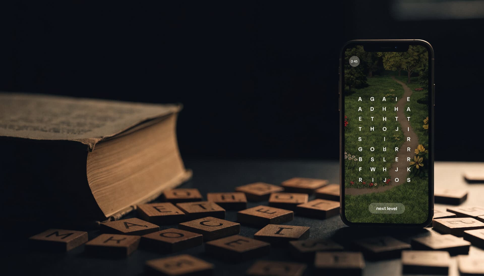 Wooden letter tiles spilled in the dark beside an iPhone showing a WordLoom word search board